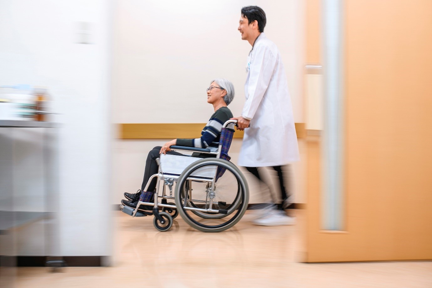 Doctor pushing patient in wheel chair